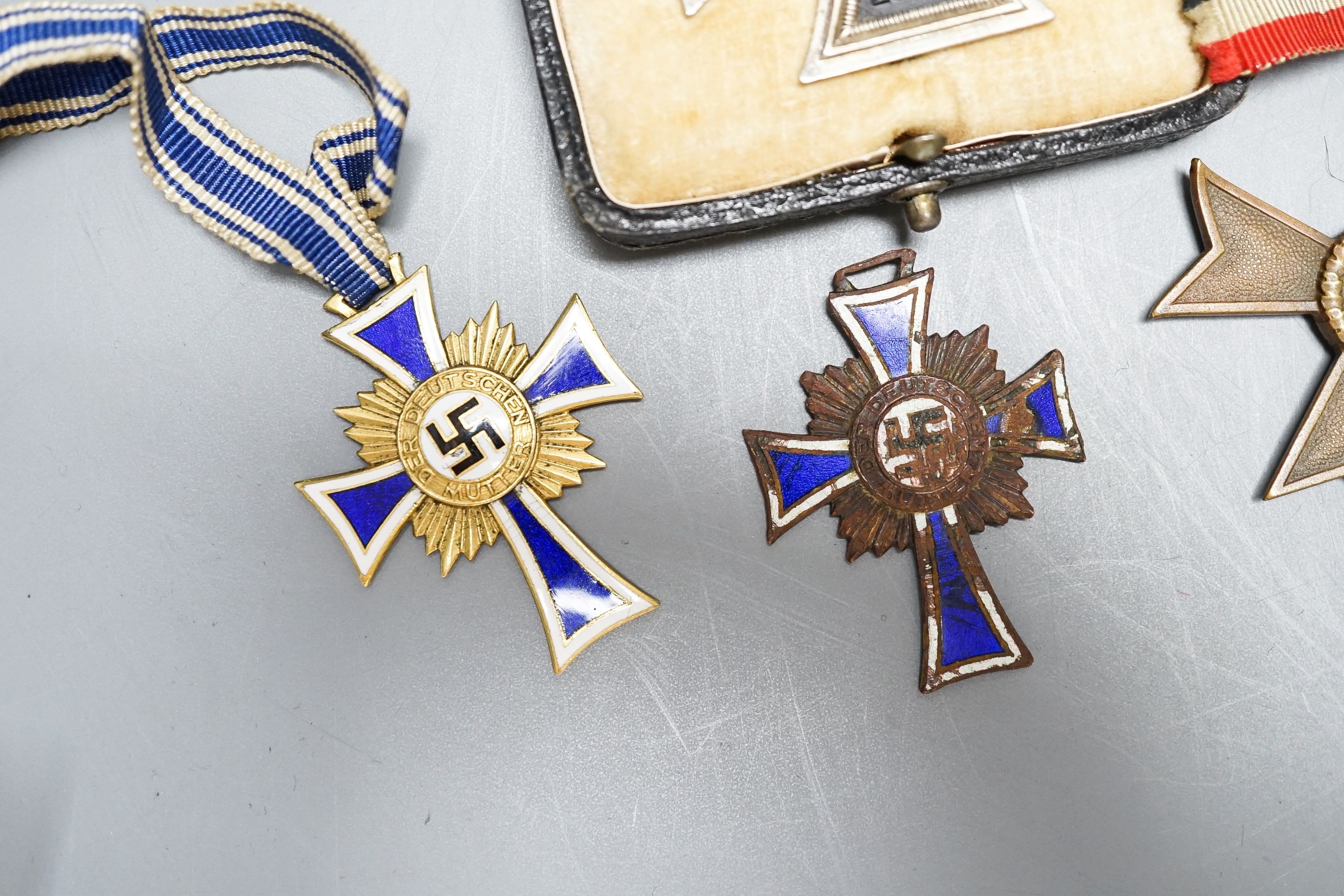 WWII Third Reich medals to include a Cross of Honour of the German Mother in gilt, another damaged in bronze, War Merit Cross (without swords), a 1939 Iron Cross and a Third Reich cuff link (5)